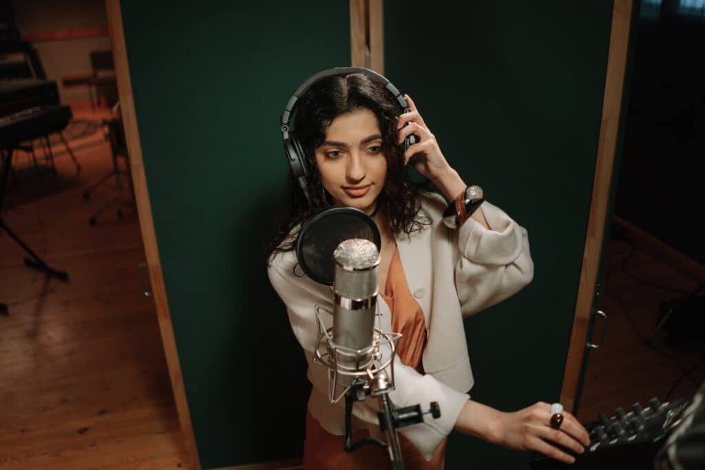 female artist recording a song in a studio